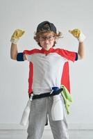 Cheerful boy showing biceps in studio photo