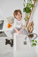 Smiling boy doing hygiene routine in kitchen photo