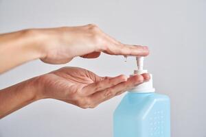 Anonymous person applying sanitizer on hand photo