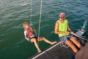 Smiling guy pulling rope with happy kid to make counterweight on photo