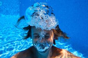 Funny preteen boy swimming in pool photo