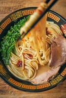 Delicious ramen with cooked noodles on chopsticks photo