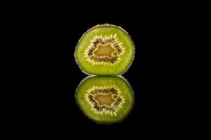 Fresh green kiwi fruit slice in black studio photo