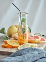 Sliced citruses and lemonade on cutting board photo