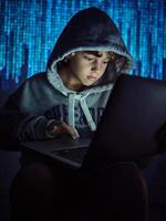 Serious boy using laptop on binary code background photo
