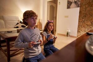 Exited children sitting on knees and playing game with joystick photo
