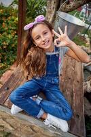 Smiling girl showing OK gesture on bench photo