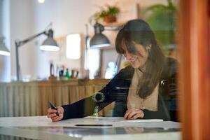 Smiling woman making sketches on papers in studio photo