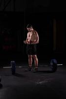 Man sportsman preparing for lifting barbell with plates photo
