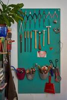 Set of various jewelry tools hanging on wall photo
