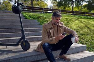 Unshaven man using smartphone in park photo