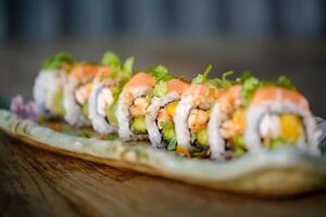 sUramaki sushi with salmon and fresh vegetable with avocado on marble tray photo