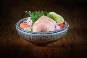 Bowl with delicious sashimi on wooden table photo