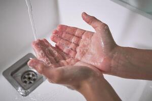 Anonymous kid washing hands with soap photo