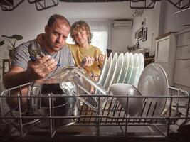 Serious man and son near broken dishwasher photo