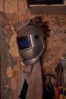 Welding mask in shabby workshop photo