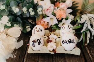 Easter eggs in container between decorative plants photo
