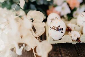Easter eggs hand painted by children with messages in an egg cup photo
