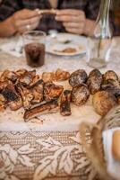 unrecognizable peron eating ribs and potatoes from barbeque in the table photo
