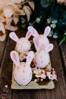 Easter eggs with rabbit ears in container photo