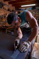 Man making marks on metal sheet in workshop photo