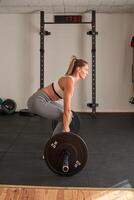 Woman doing exercises with barbell in gym photo