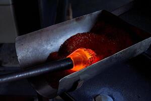 Glassblowing of hot object in workshop photo