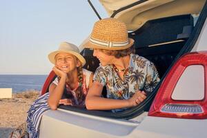 Girl inside the trunk of a car making a wait gesture with happy photo