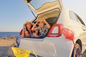 Kids inside the trunk of the car making jokes while touching the photo