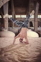 Man performing handstand while breaking dance in abandoned building photo