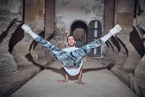 Man dancing break dance in abandoned building photo