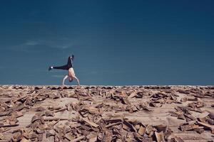 Unrecognizable man performing handstand element of freestyle dance on roof photo