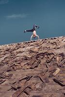 Man standing on two hands while dancing breakdance on roof photo