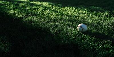 Baseball field at sunset with bases standing in fading light, golden sky creating a nostalgic scene photo