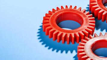 Red plastic gears creating a teamwork concept on blue background photo