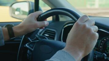 Close-up of male driver driving car, gripping steering wheel and turning on turn signal before overtaking video