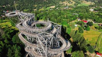 Aerial view of Sky Walk spiral observation tower in Sweradow Zdroj, Poland, surrounded by green forests video
