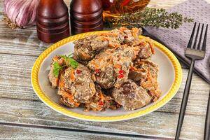 A plate of meat and vegetables on a table photo