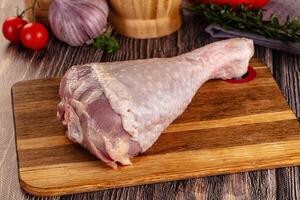 A raw chicken on a cutting board with vegetables and herbs photo