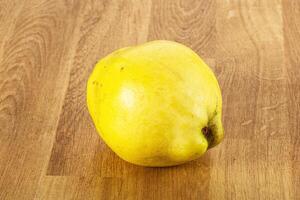 A yellow fruit on a wooden table photo