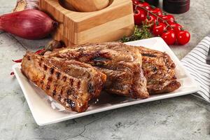 A plate of meat on a table with a knife and a knife block photo
