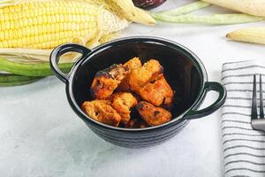 A bowl of food with corn, corn on the cob, and a fork photo