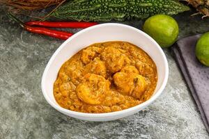 A bowl of curry with some vegetables and spices photo