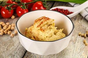 A bowl of hummus with tomatoes and other ingredients photo