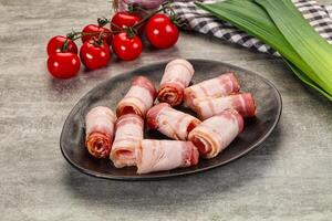 Bacon wrapped in bacon on a plate with tomatoes photo