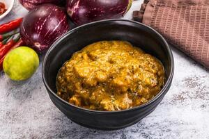 A bowl of curry with vegetables and spices photo