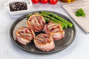 Bacon wrapped pork chops with asparagus and tomatoes photo