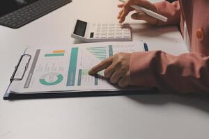 A woman's hand is holding a clipboard with a calculator and a pen photo
