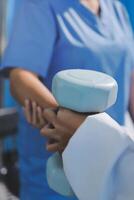 A doctor is holding a dumbbell in front of a patient photo