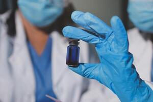 Two doctors holding a vial of liquid photo